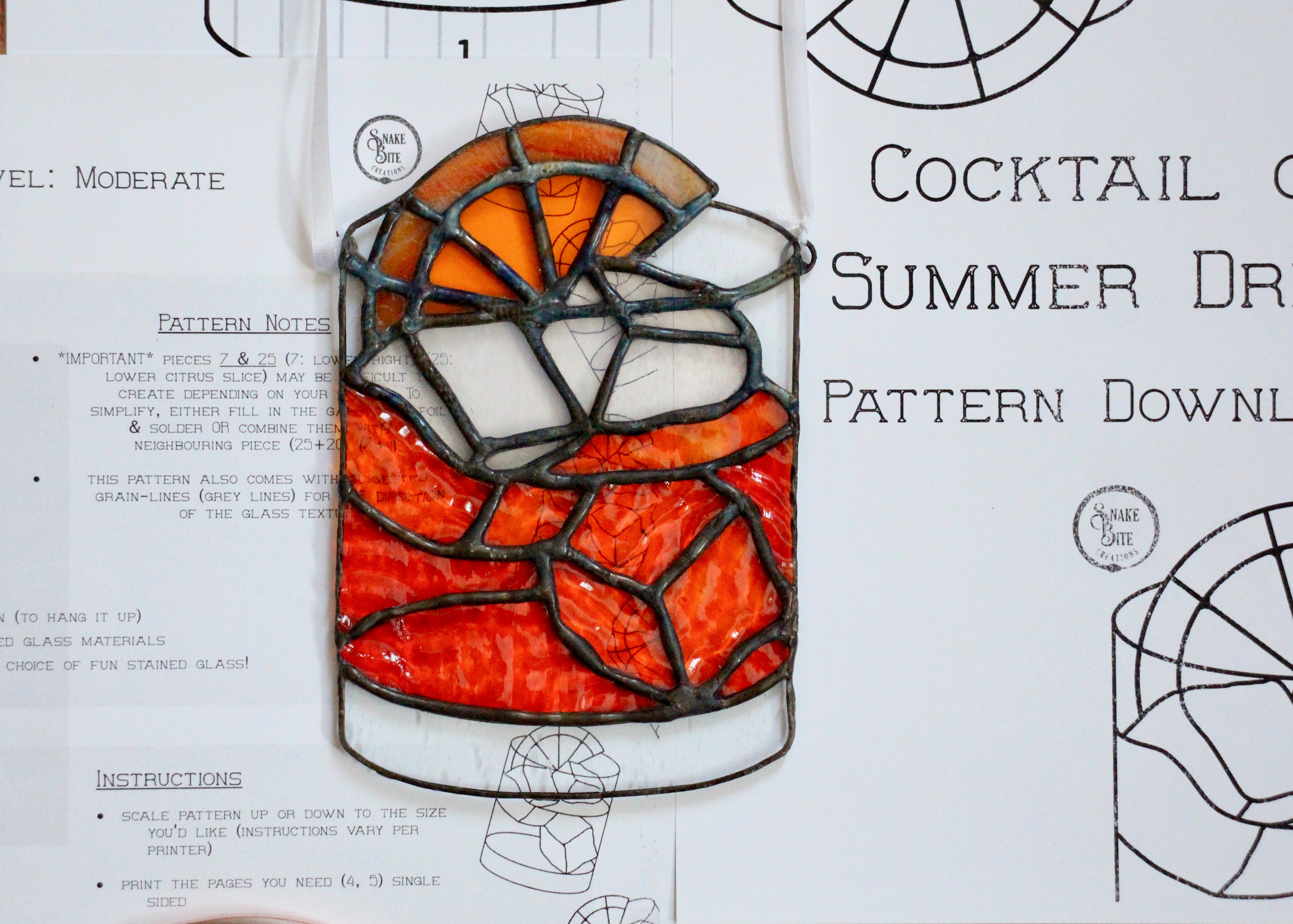 negroni cocktail with ice cubes and an orange slice on top.  Orange red in colour, 3d appearance in a glass